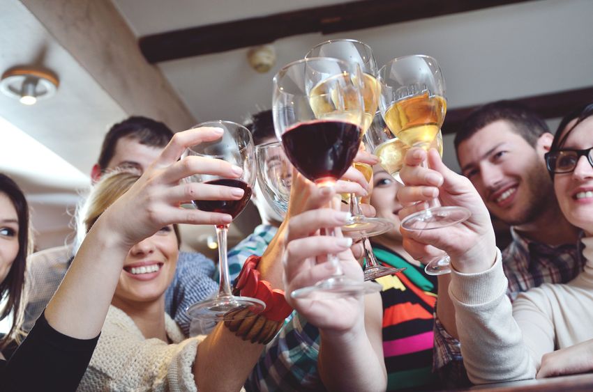 young men and women clinking glasses