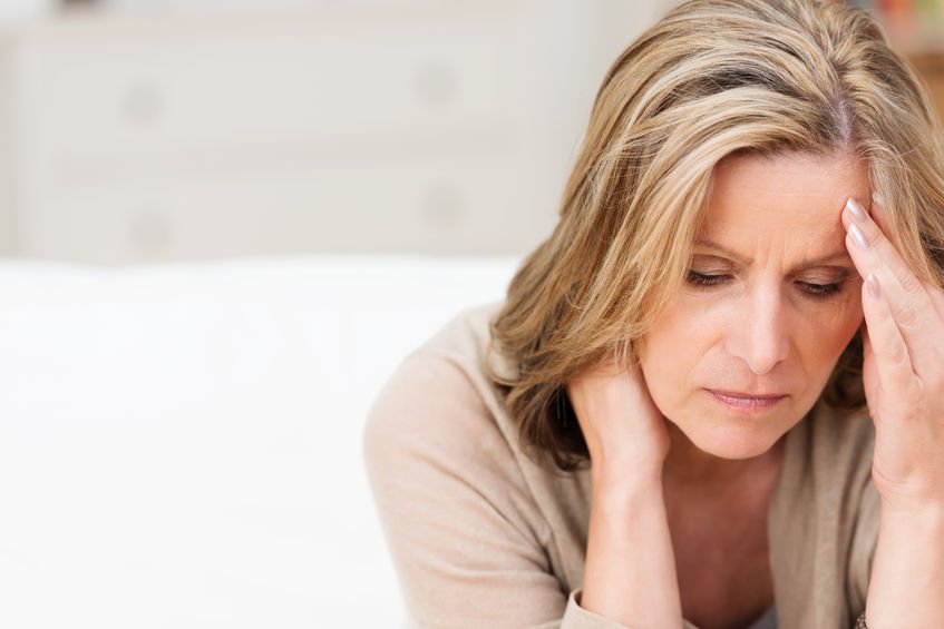 woman holding neck in pain