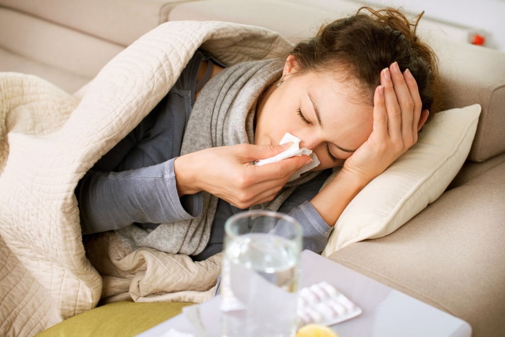 sick woman blowing nose