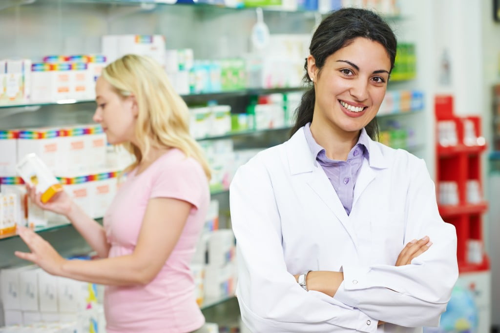 Community pharmacy: smiling pharmacist in shop