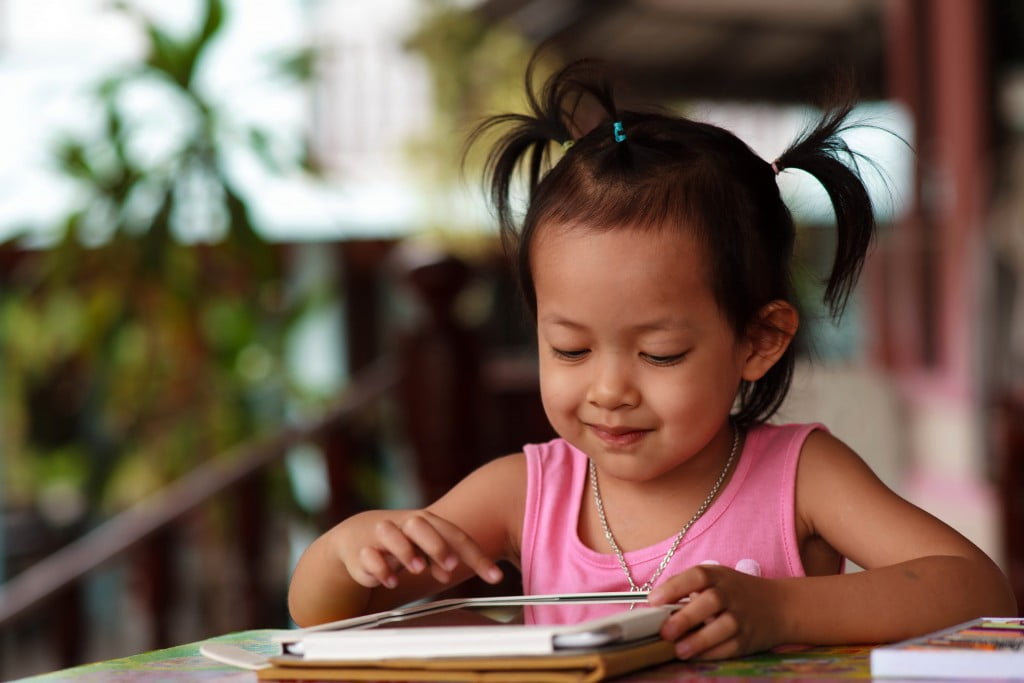 toddler girl plays with tablet