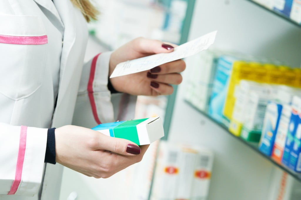 Pharmacists' hands with script and medicine box