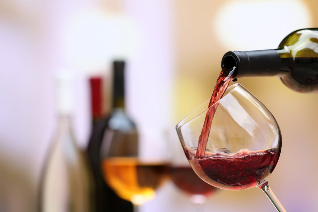glass of alcohol (red wine) being poured