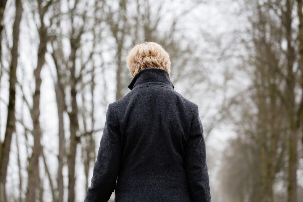 Polycystic Ovary Syndrome: woman walks away from camera into winter trees