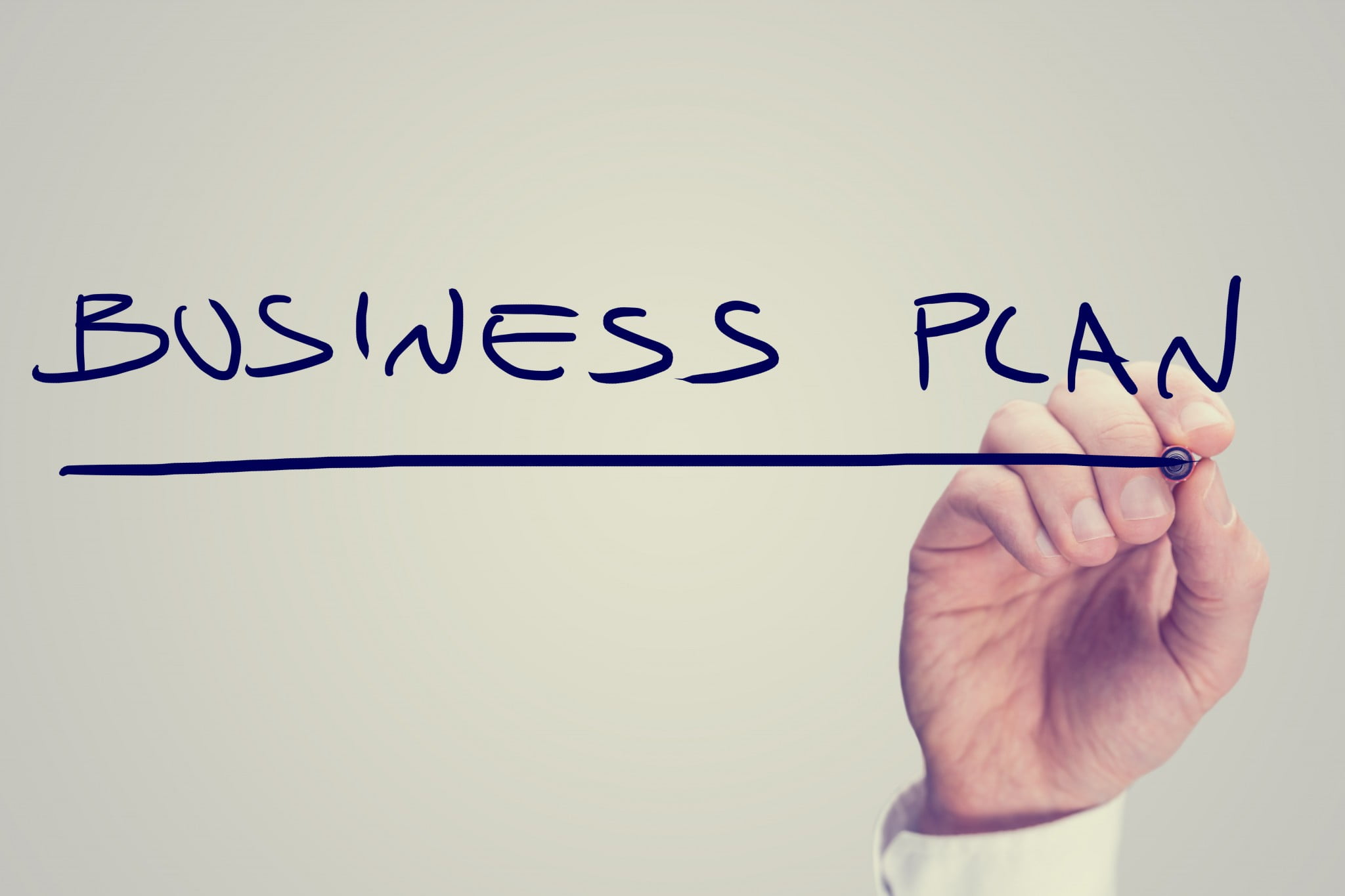 hand writes "business plan"