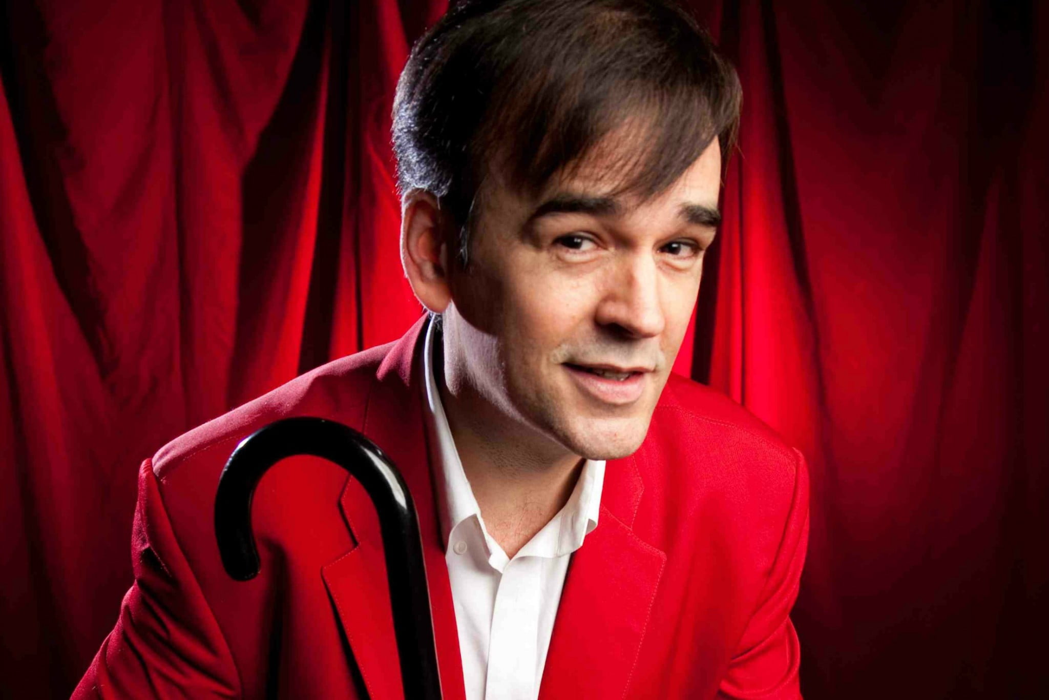 Tim Ferguson wearing red and holding cane