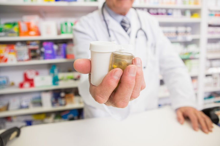 Schedule 3 - pharmacist holding out pill bottles