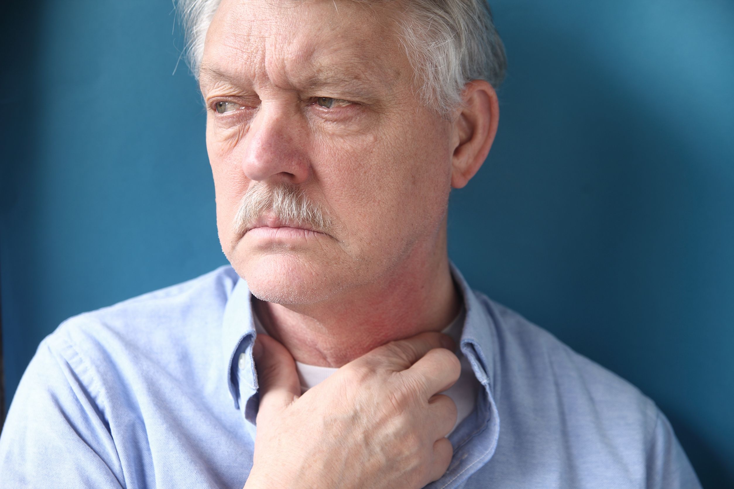 sad senior man with throat irritation