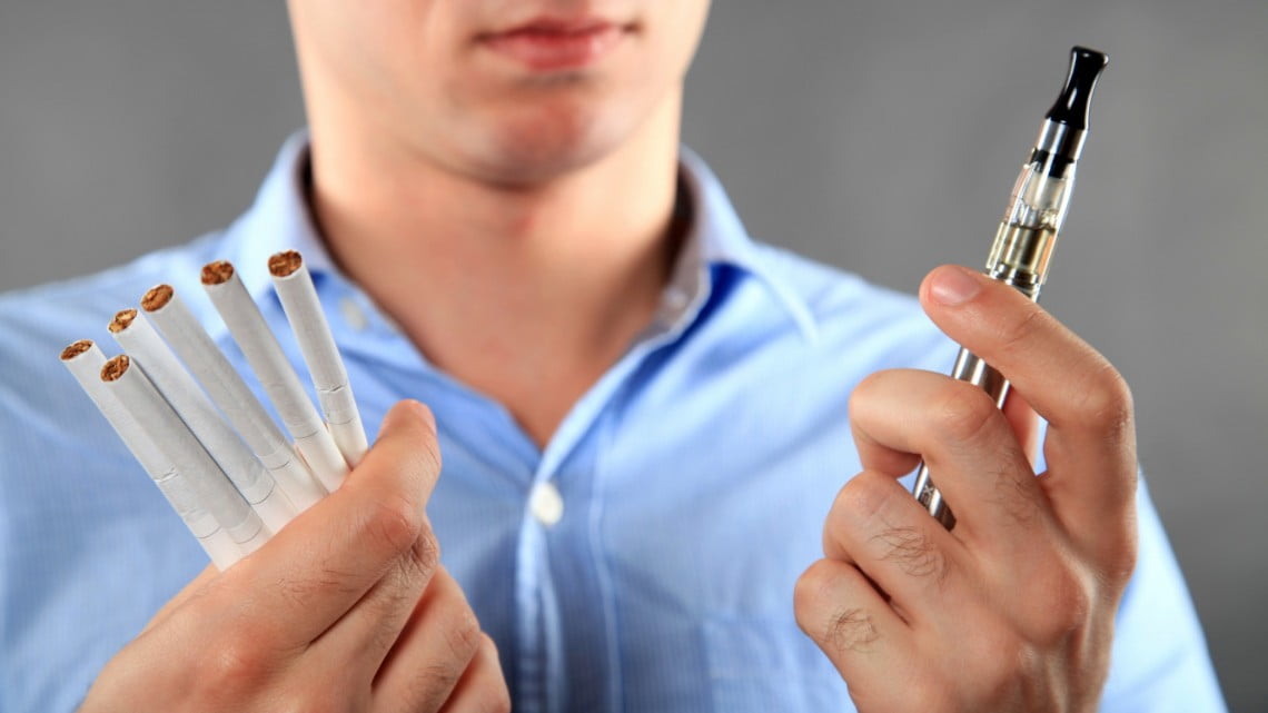 man with traditional and e-cigarettes