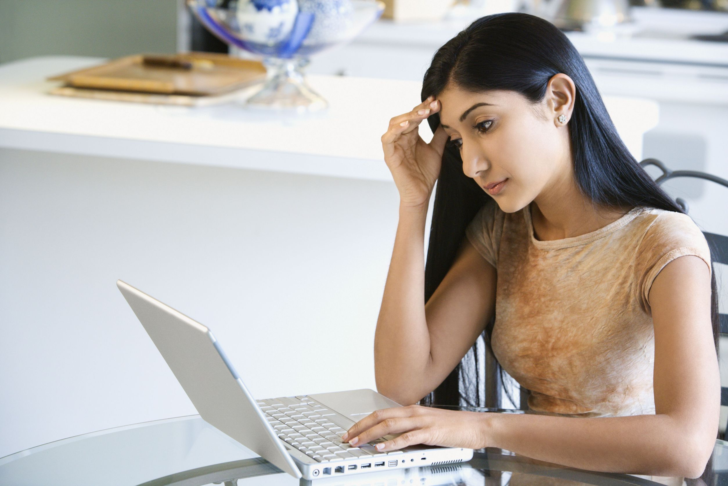 worried looking woman using laptop