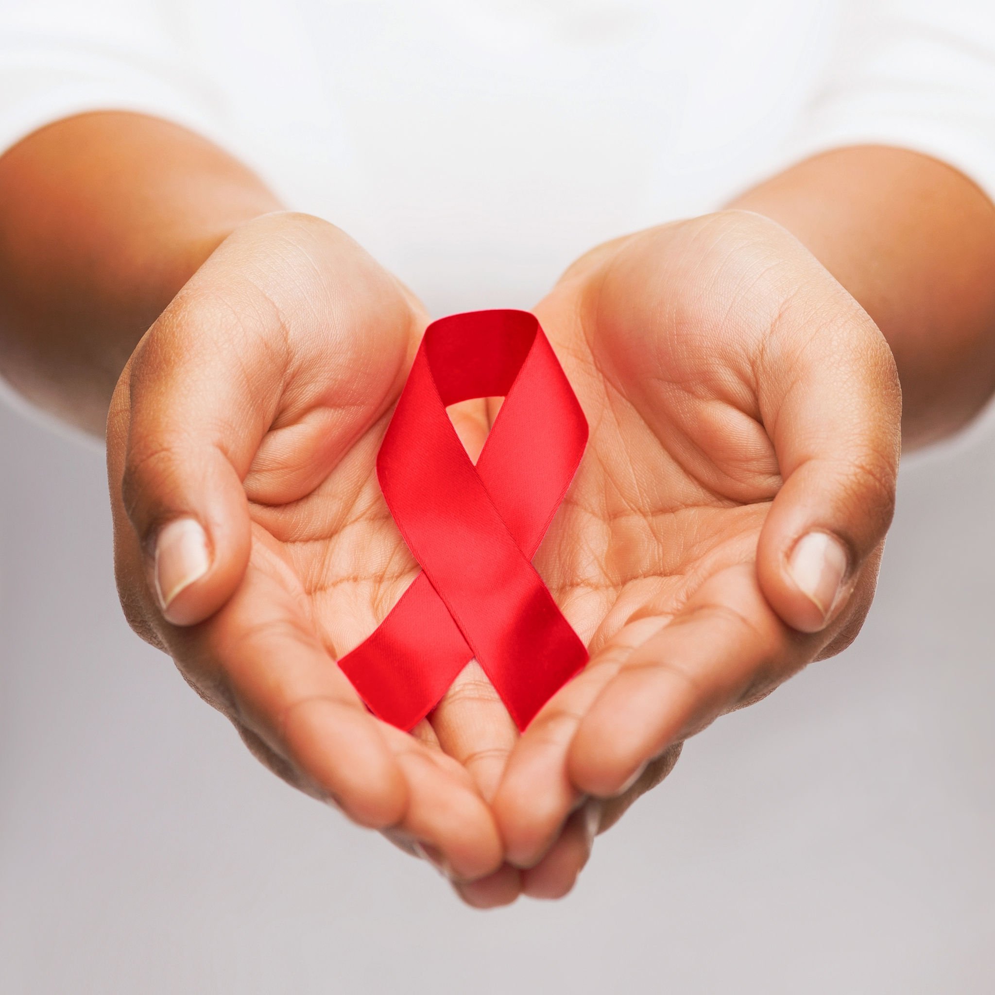 AIDS awareness ribbon in hands