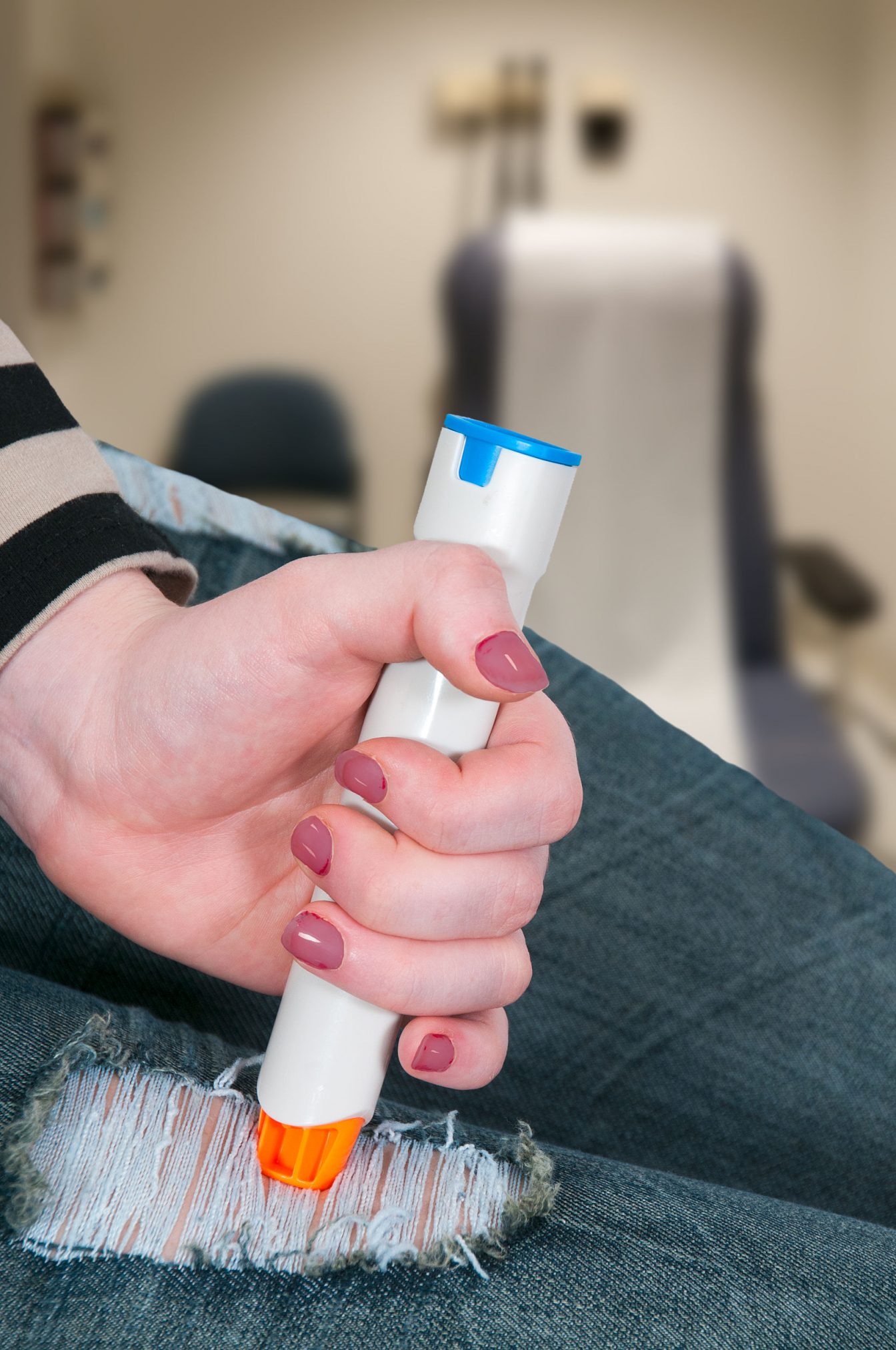 27220715 - woman injecting emergency medicine into her leg