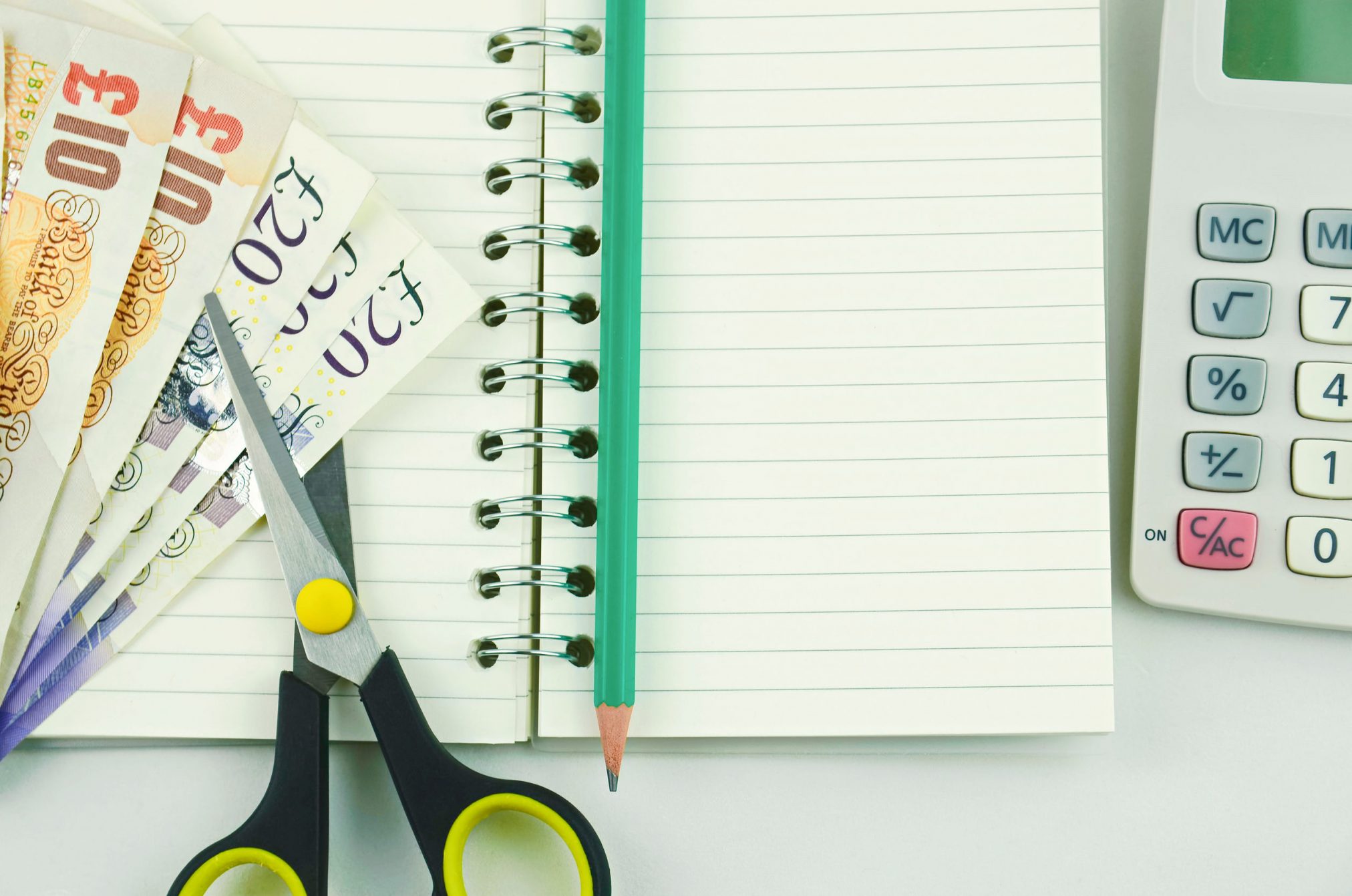 scissors cutting british pounds