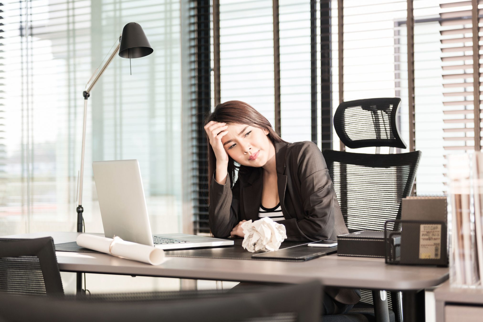 39343207 - tired and sleepy young business woman at the desk with a laptop