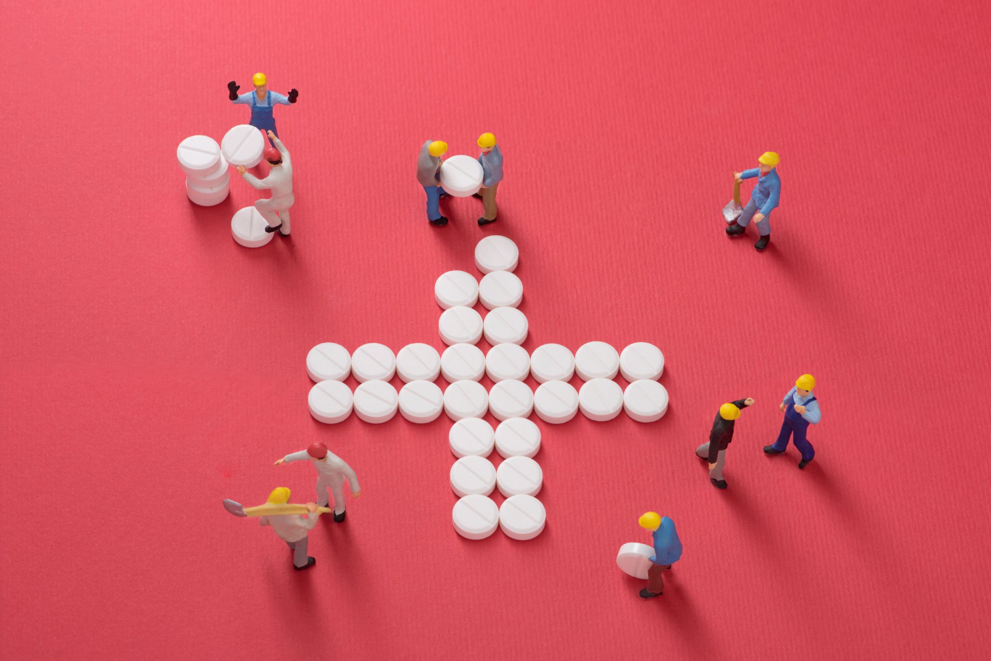 workmen with pills arranged in a cross