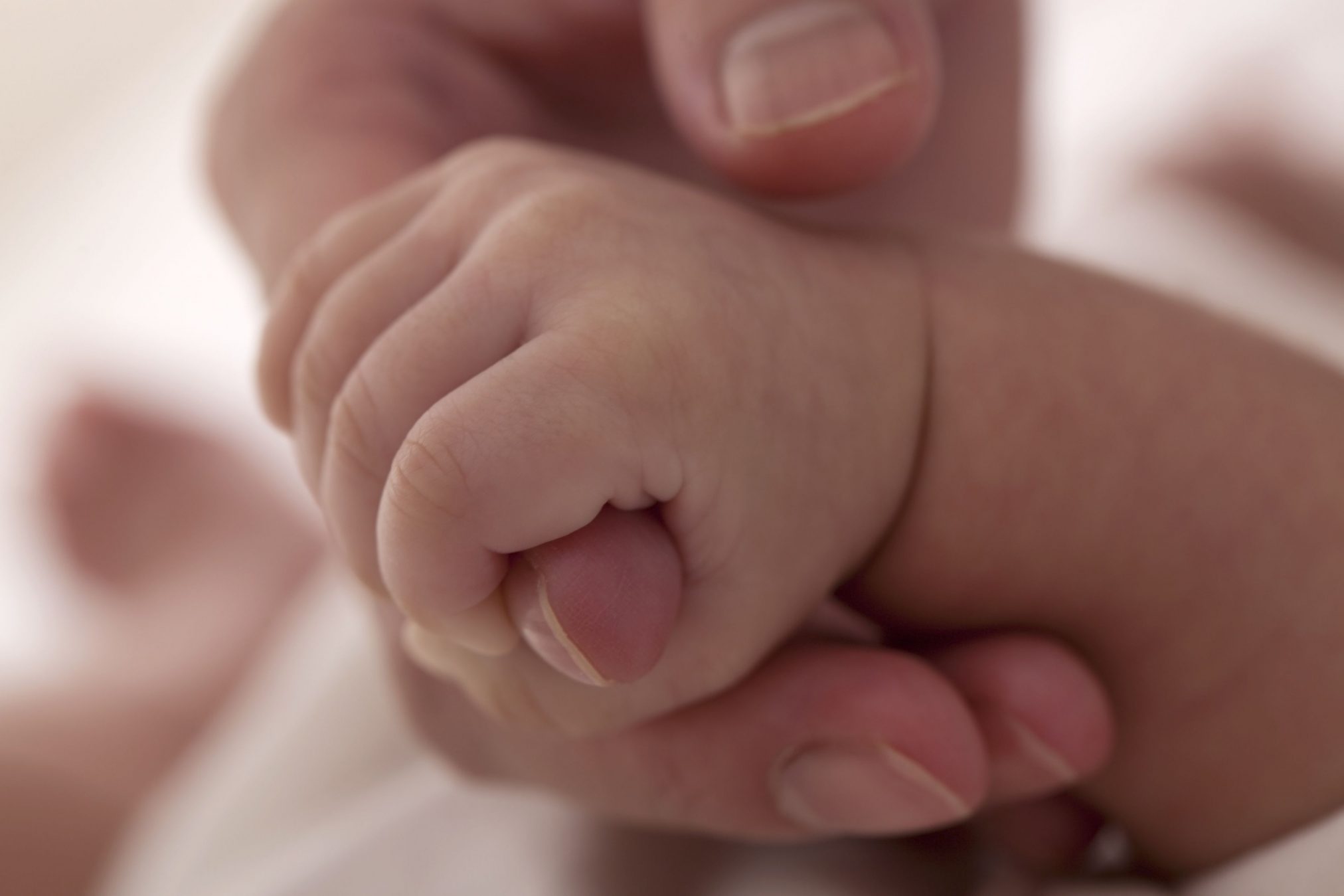 mother holding baby's hand