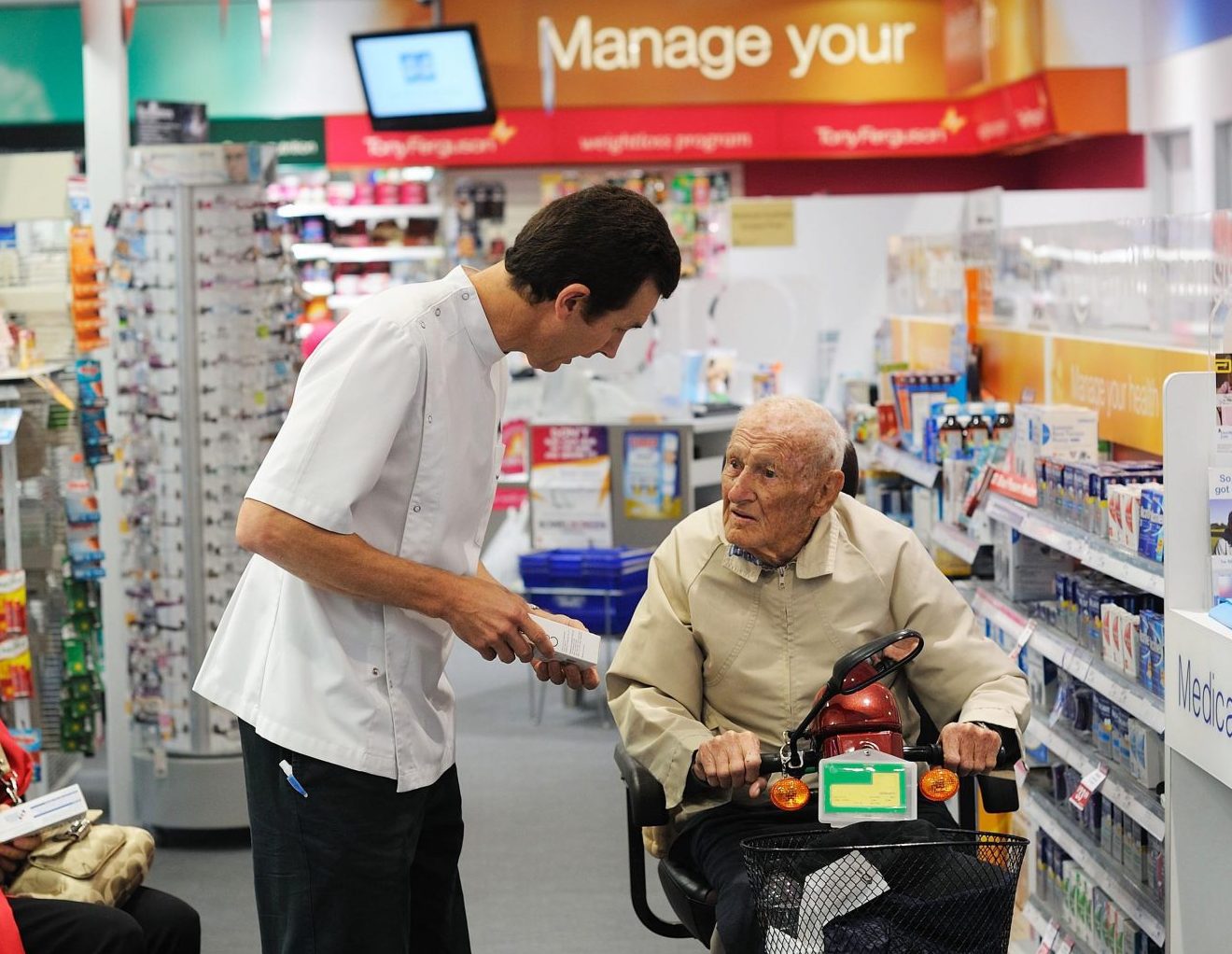 pharmacist speaking to elderly man in Terry White Chemist