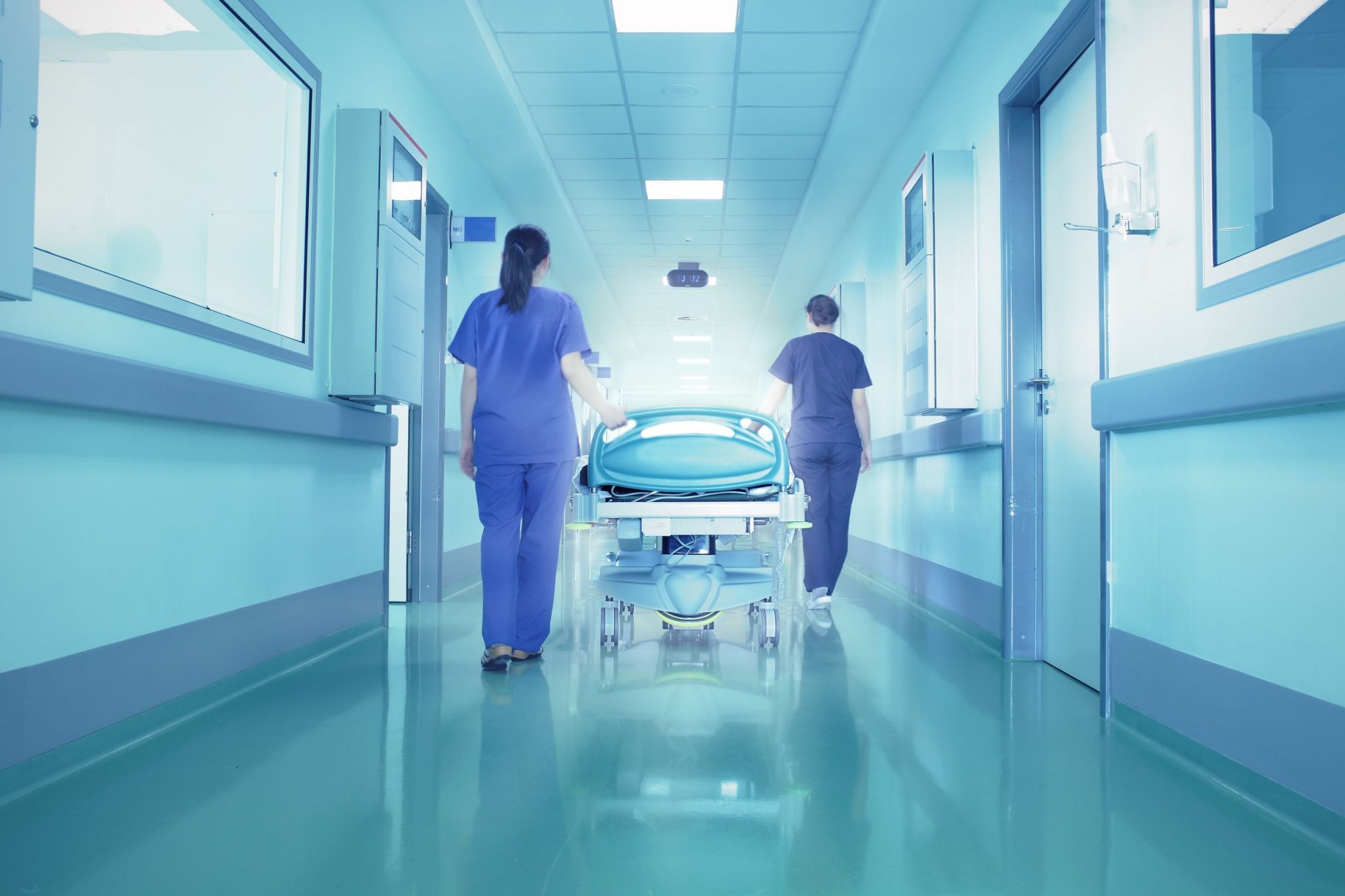 hospital staff wheel away empty gurney