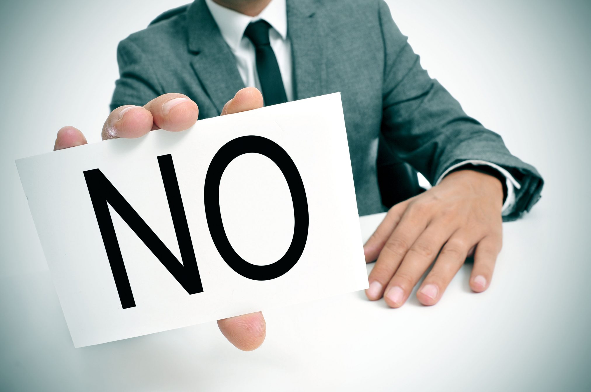 man holding 'no' sign