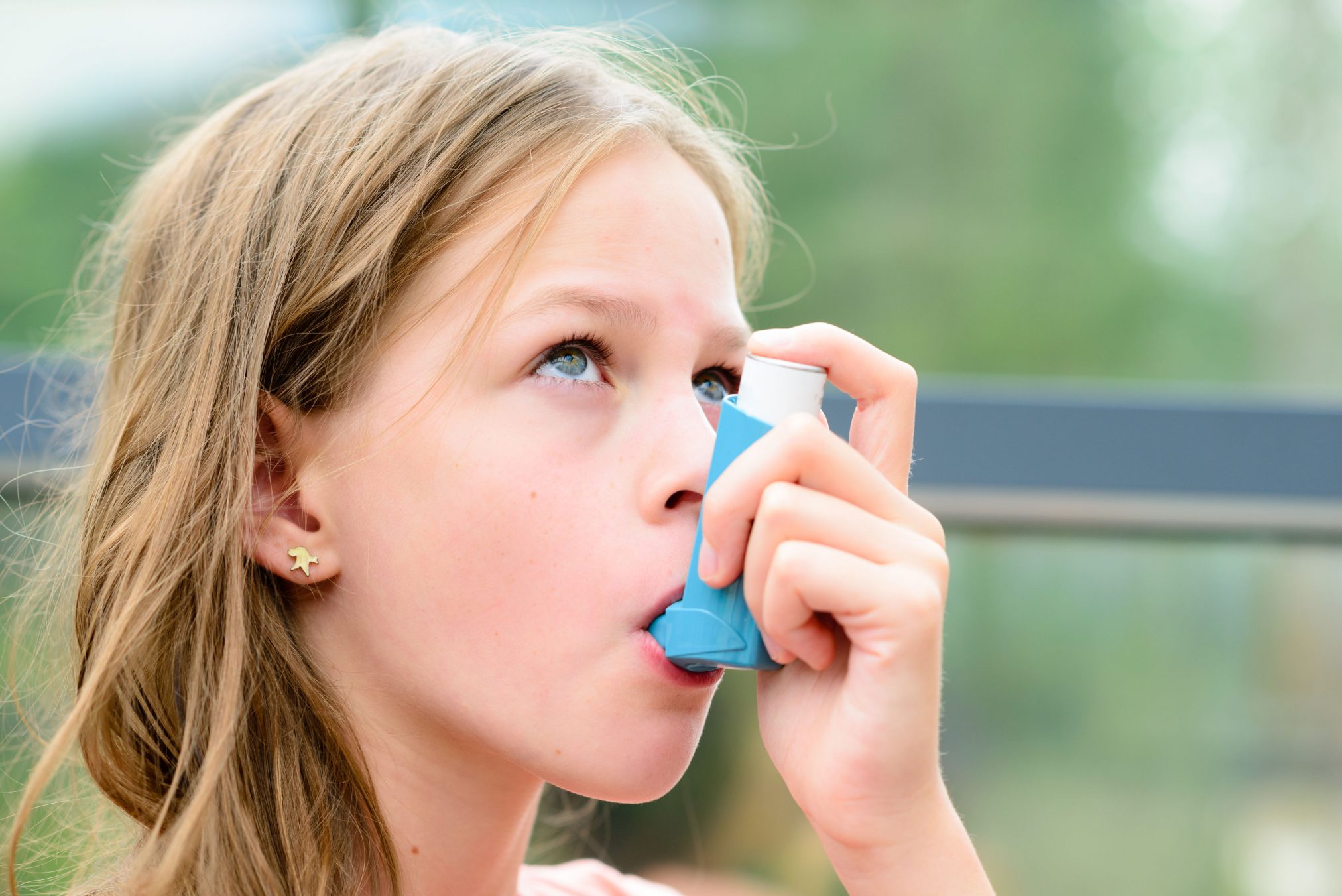 girl using asthma puffer