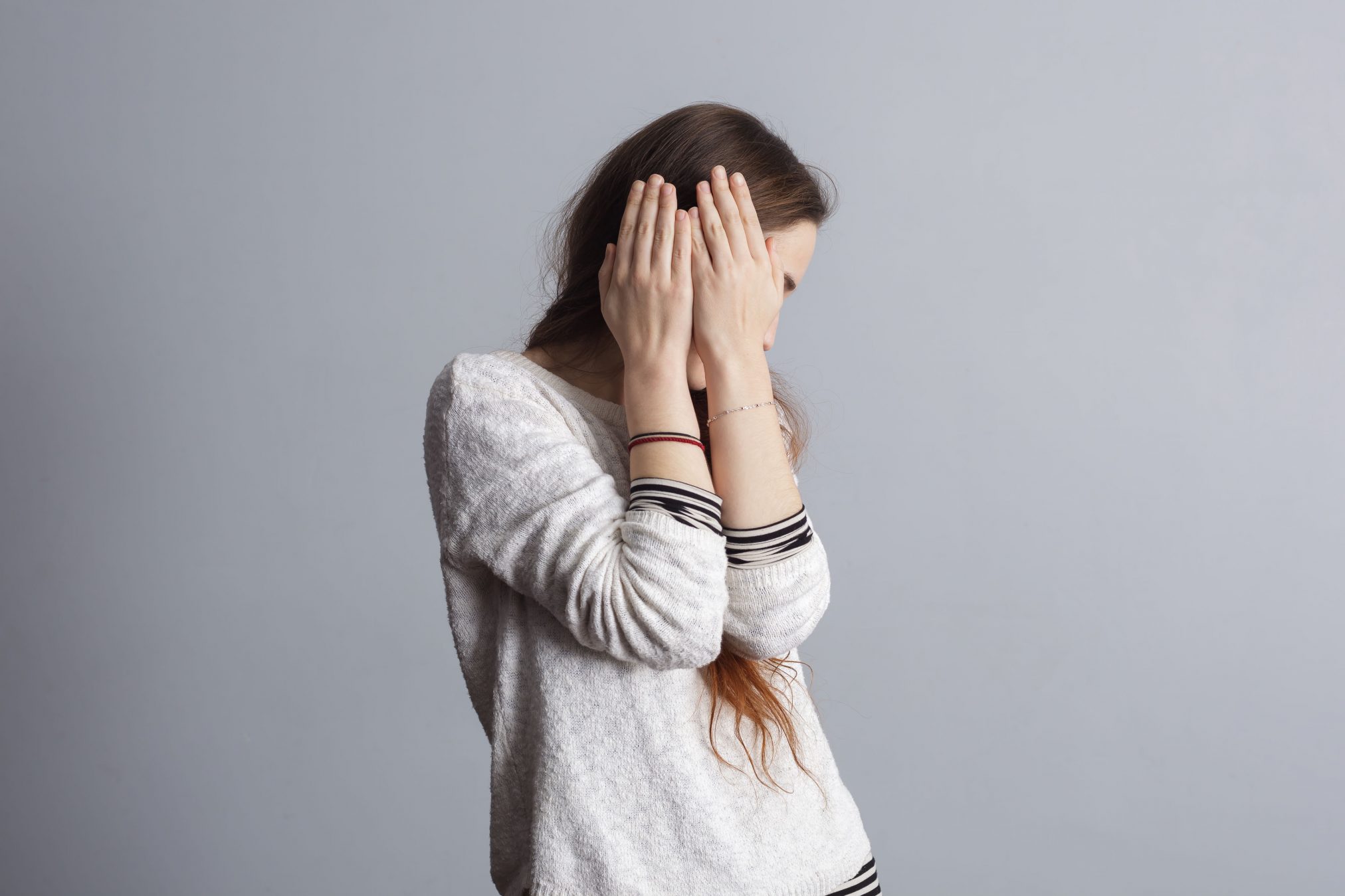 shy embarrassed young woman hiding face covering face