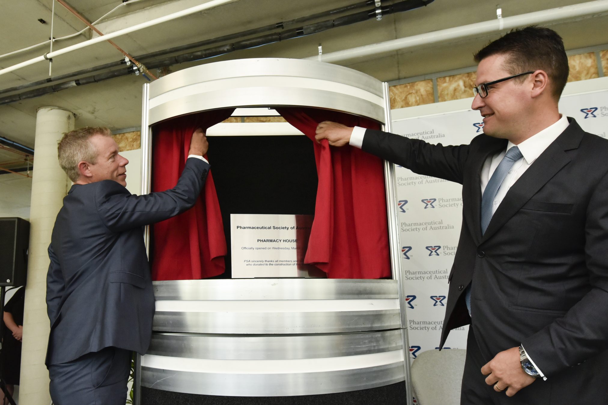 Shane Jackson and Zed Seselja unveil a plaque commemorating the launch of the new Pharmacy House.
