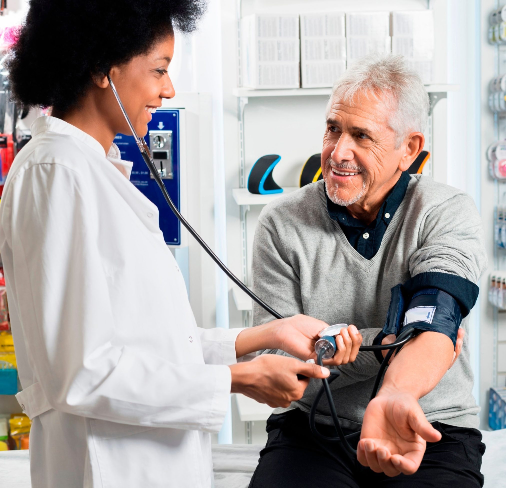 pharmacist checking blood pressure of senior man