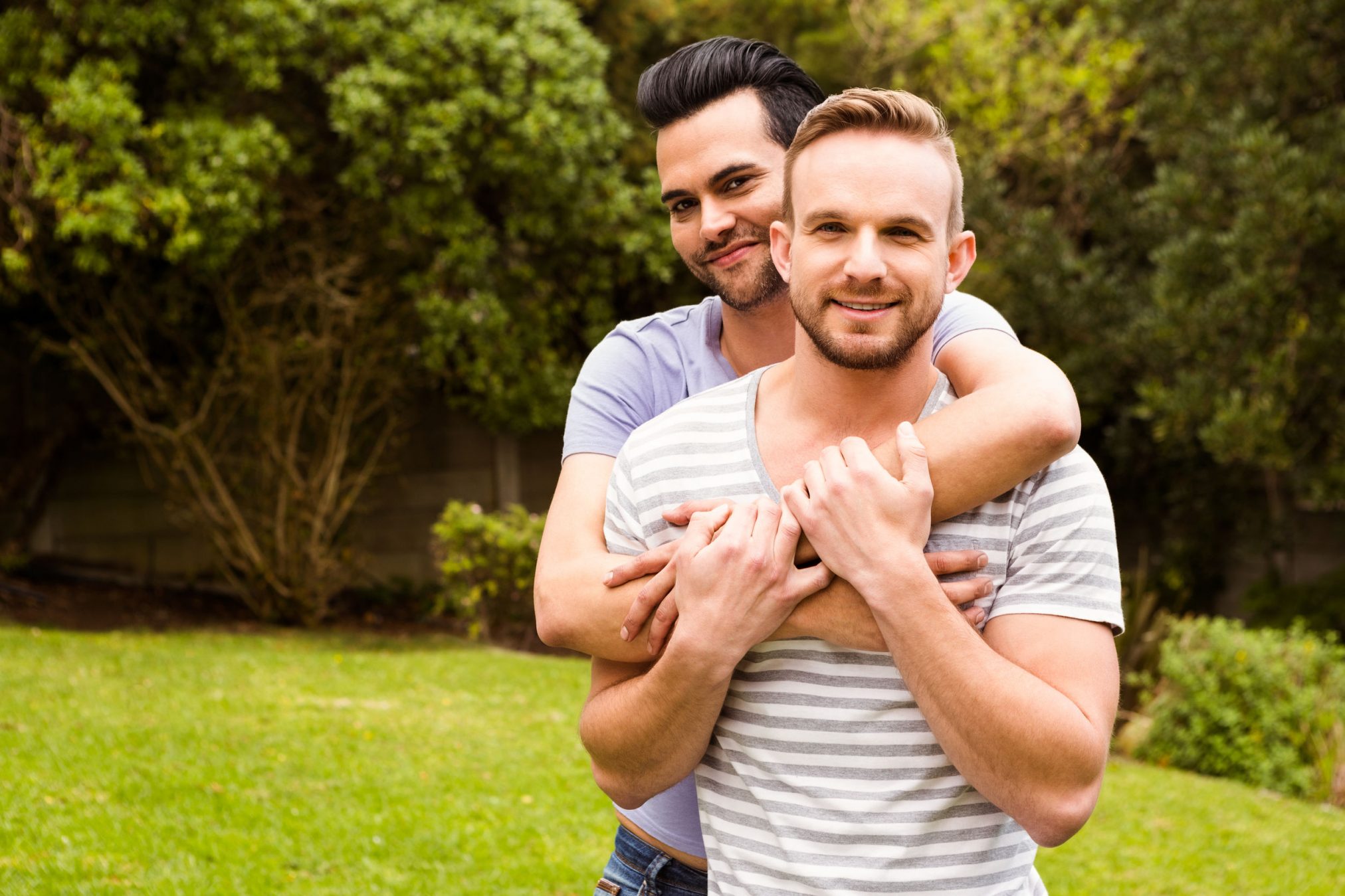 happy gay couple in park