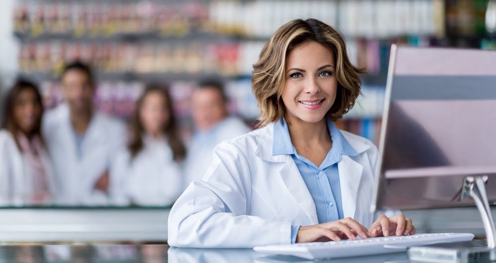 Cashier woman at the pharmacy typing on the computer
