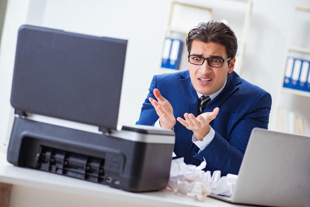 confused businessman with fax machine