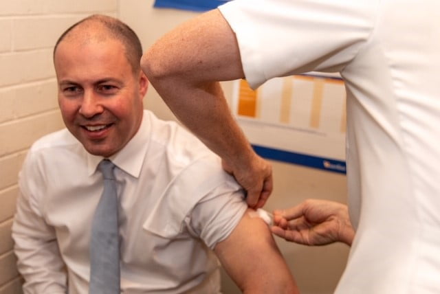 Josh Frydenberg rolls up his sleeve for his flu shot at the Scott McLaren Pharmacy.