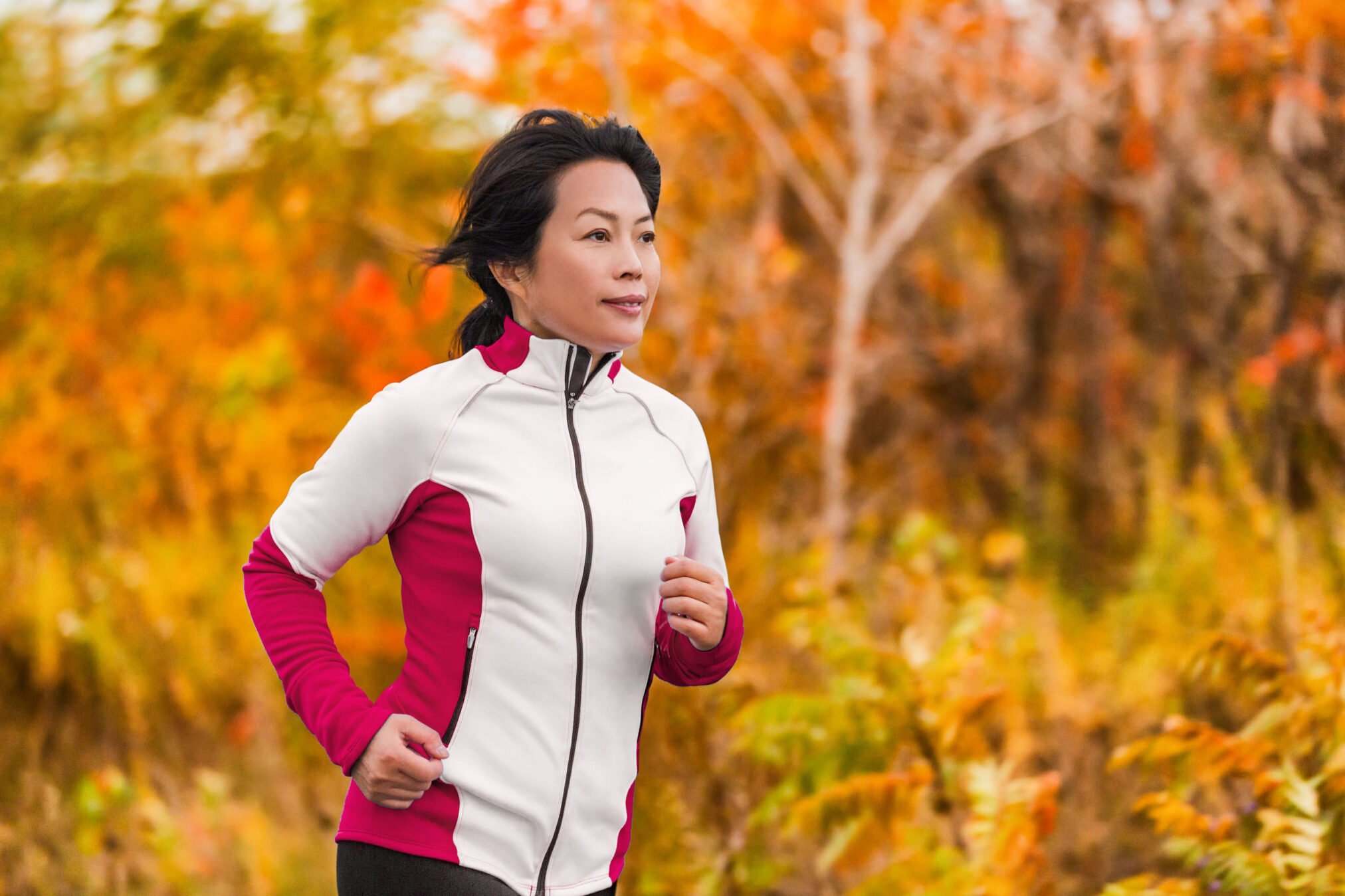 Fiftysomething woman going for jog against autumn background