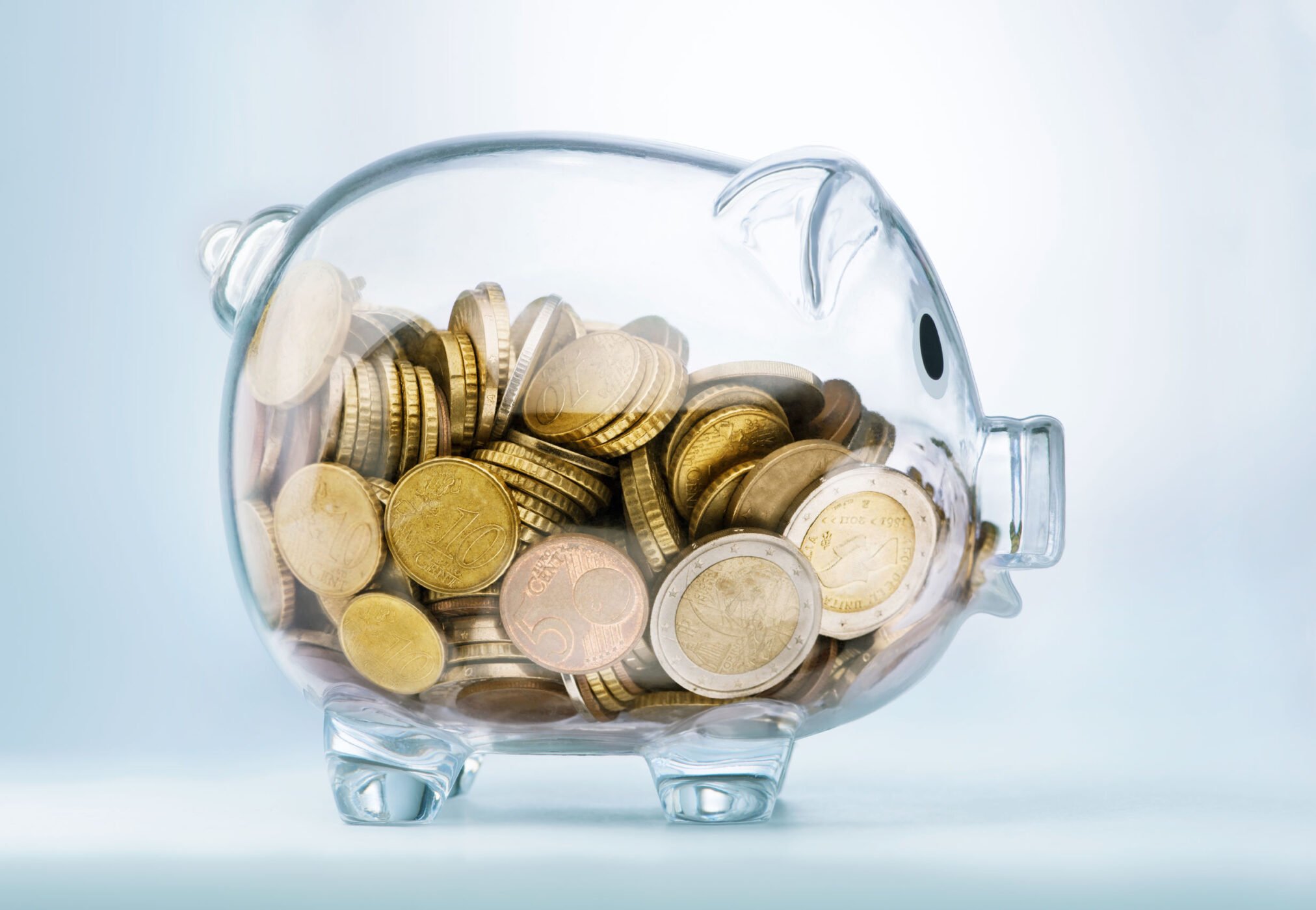 A see through piggy bank with money coins euro