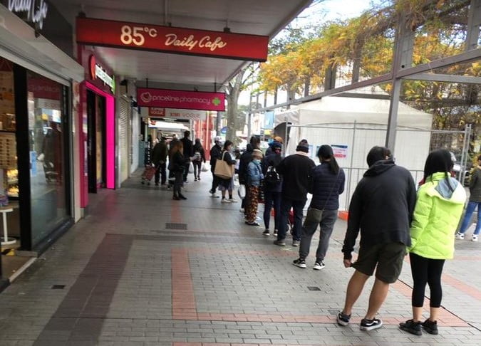 Queue of people in the street waiting outside Priceline Pharmacy